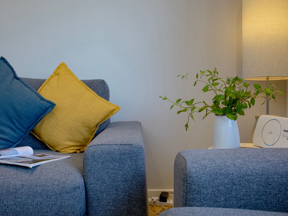 A living room with a sofa and lamp at Mariners Retreat, 8 Pottery Cottages, Dartmouth