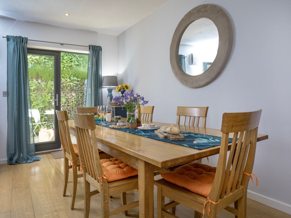 A dining room with a wooden table and chairs at Mariners Retreat, 8 Pottery Cottages, Dartmouth