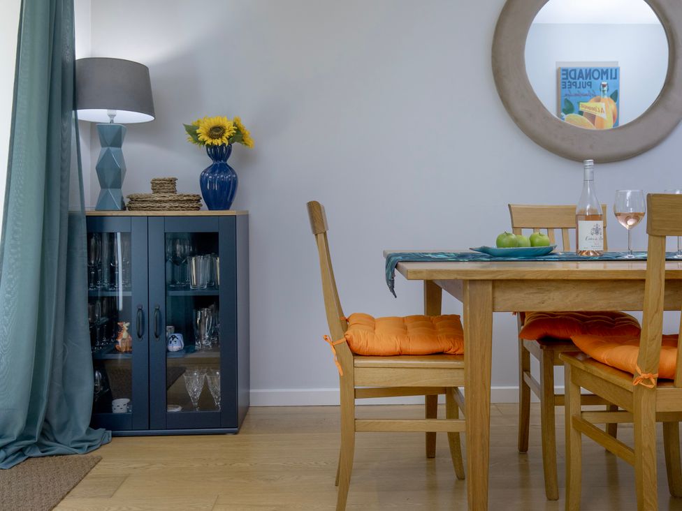 A dining room with a table and chairs at Mariners Retreat, 8 Pottery Cottages in Dartmouth