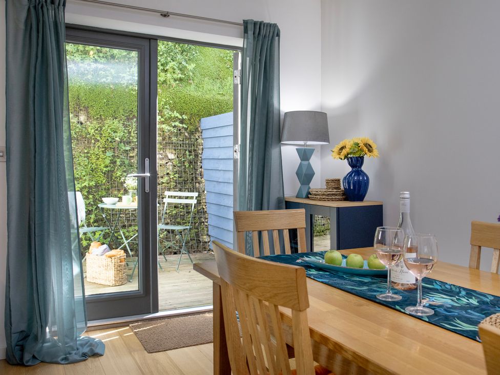 A dining room with a table and chairs at Mariners Retreat, 8 Pottery Cottages in Dartmouth