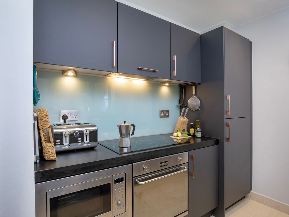 A kitchen with cooking appliances and utensils at Mariners Retreat, 8 Pottery Cottages in Dartmouth