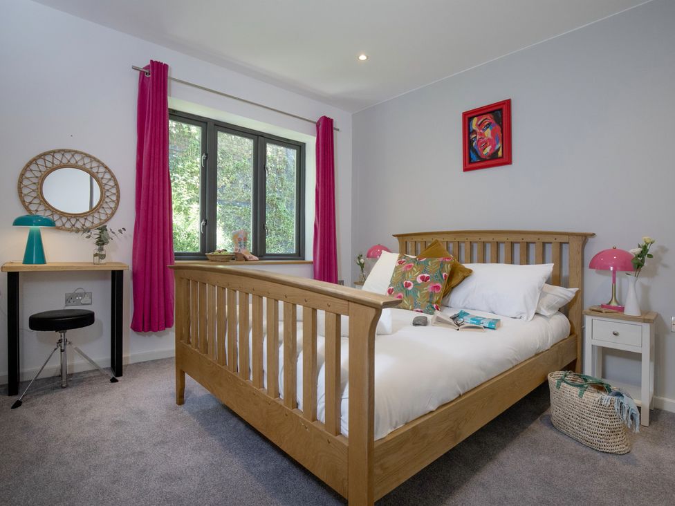 A bedroom with a bed and desk at Mariners Retreat, 8 Pottery Cottages, Dartmouth