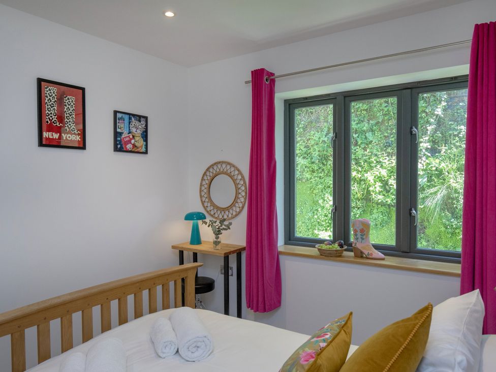 A bedroom with a bed and window at Mariners Retreat, 8 Pottery Cottages in Dartmouth