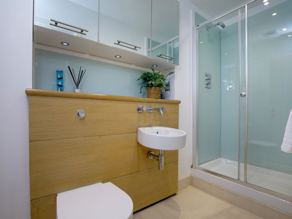 A bathroom with a sink and shower at Mariners Retreat, 8 Pottery Cottages in Dartmouth