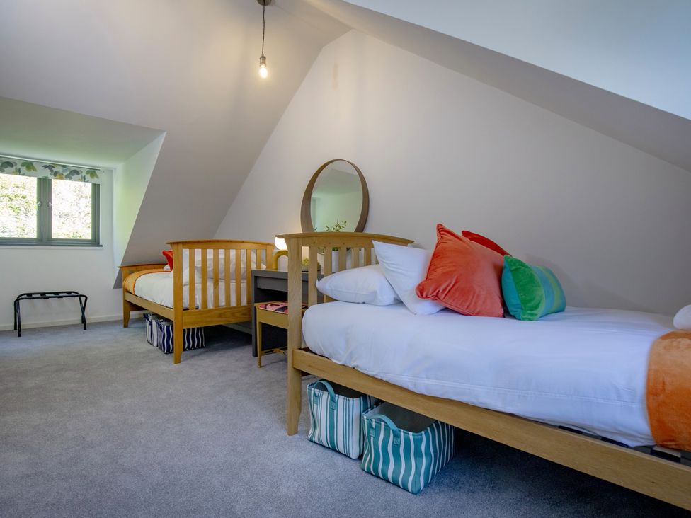 A bedroom with two beds and a desk at Mariners Retreat, 8 Pottery Cottages, Dartmouth