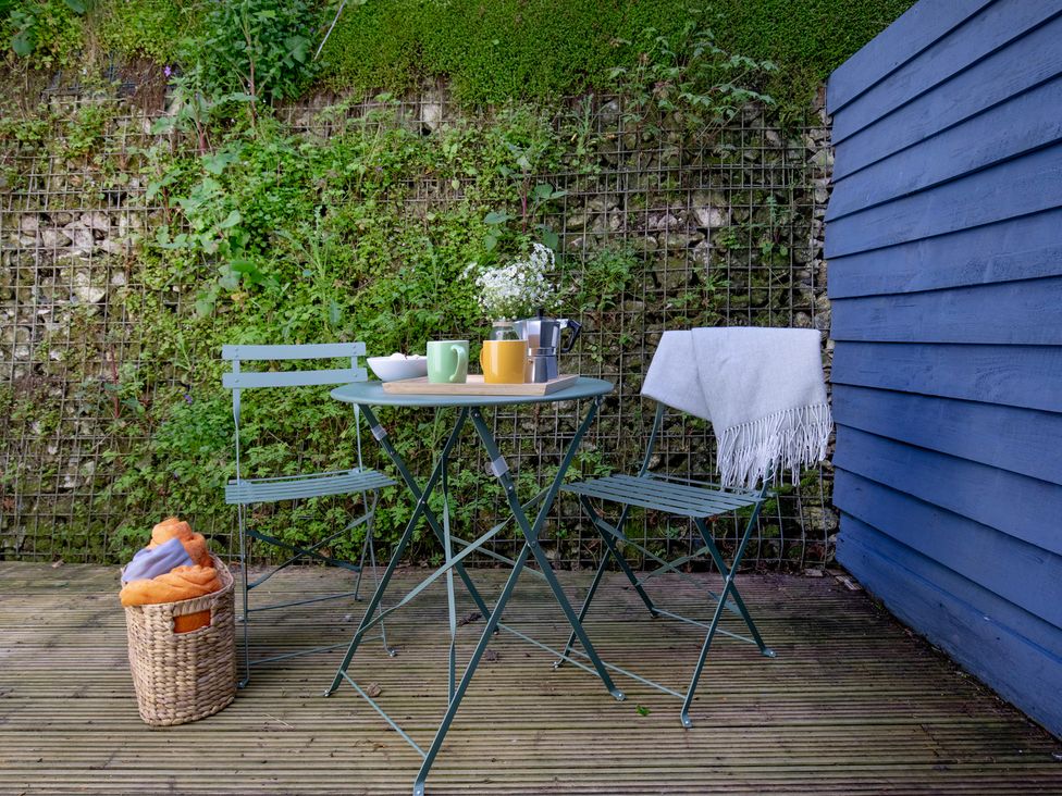 An outdoor seating area with a table and chairs at Mariners Retreat, 8 Pottery Cottages, Dartmouth