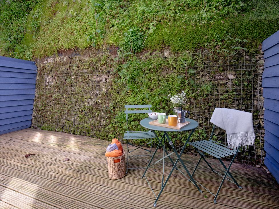A garden with a table and chairs at Mariners Retreat, 8 Pottery Cottages in Dartmouth