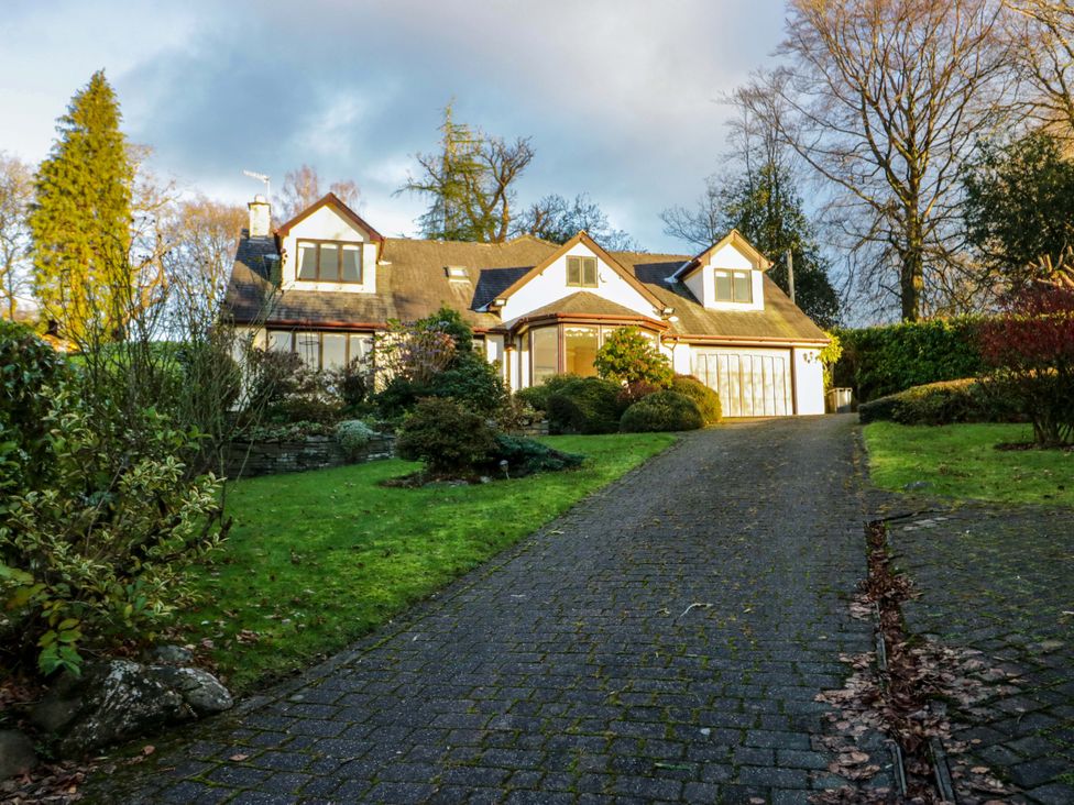 A house with a driveway and garden at Marina View in Bowness-On-Windermere