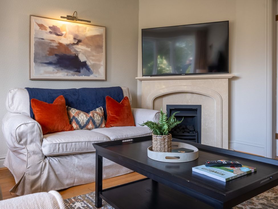 A living room with a sofa and television at Marina View, Bowness-On-Windermere