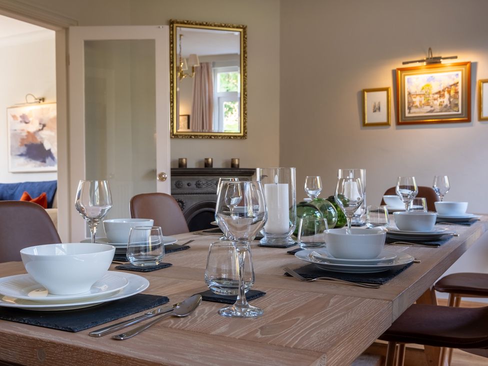 A dining table set with dinnerware and glasses at Marina View in Bowness-On-Windermere