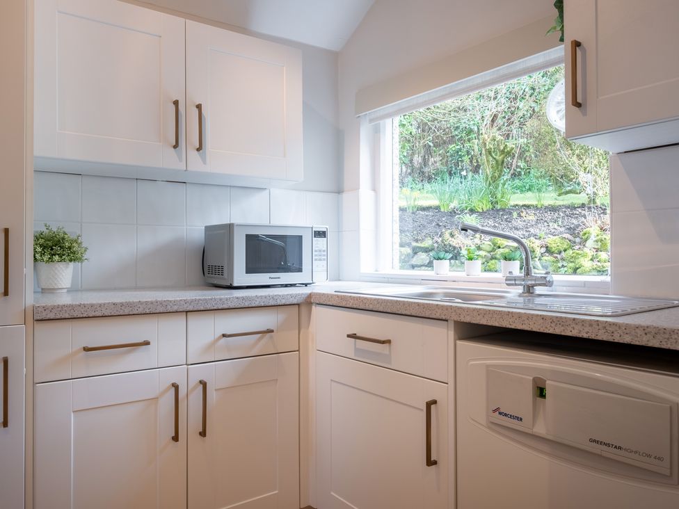 A kitchen with a microwave and a sink at Marina View in Bowness-On-Windermere
