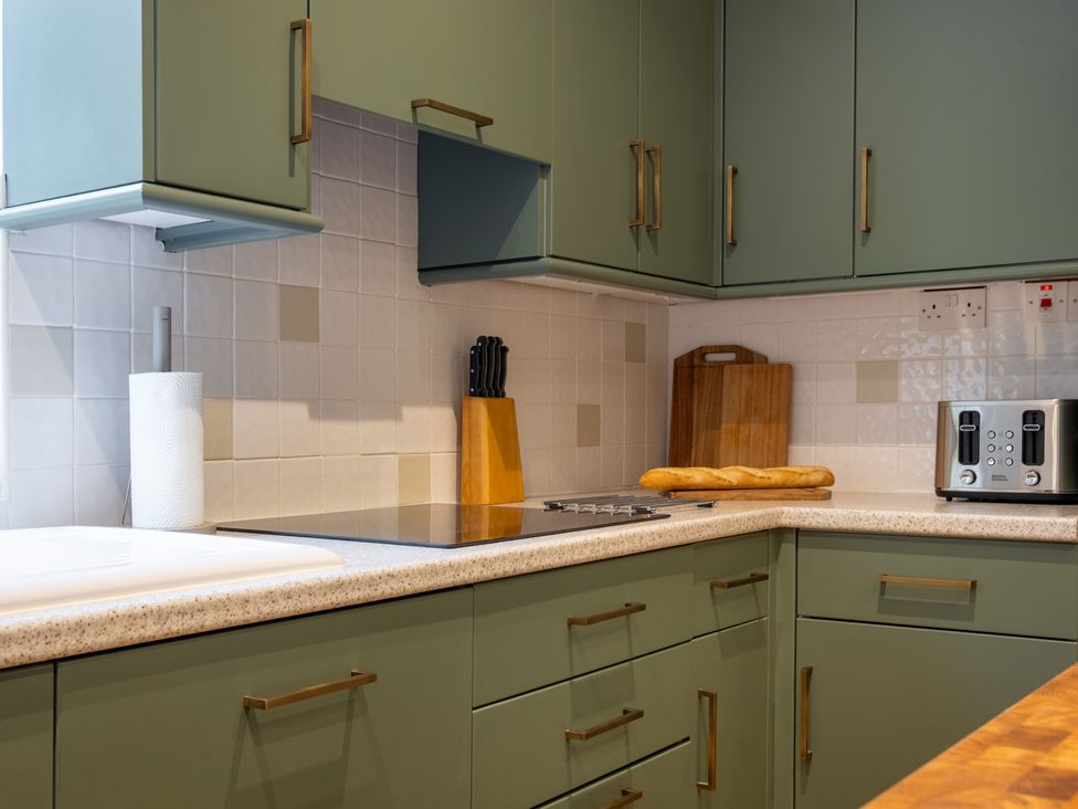 A kitchen with cabinets and appliances at Marina View in Bowness-On-Windermere