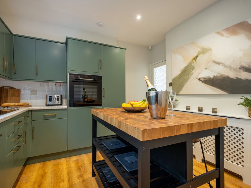A kitchen with cabinets and an island at Marina View in Bowness-On-Windermere