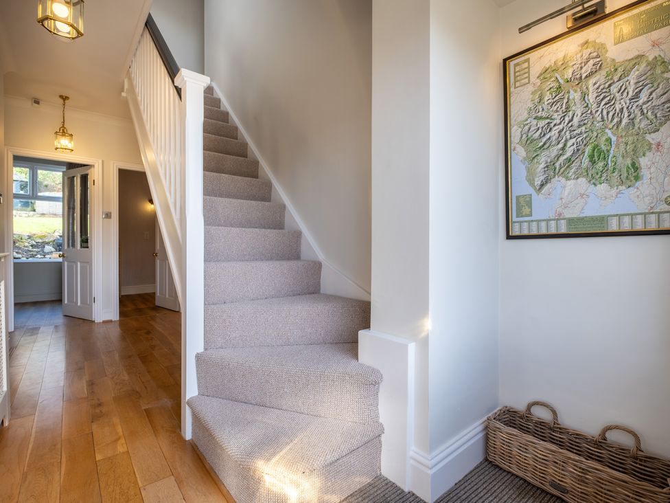 A hallway with a staircase and a map at Marina View in Bowness-On-Windermere