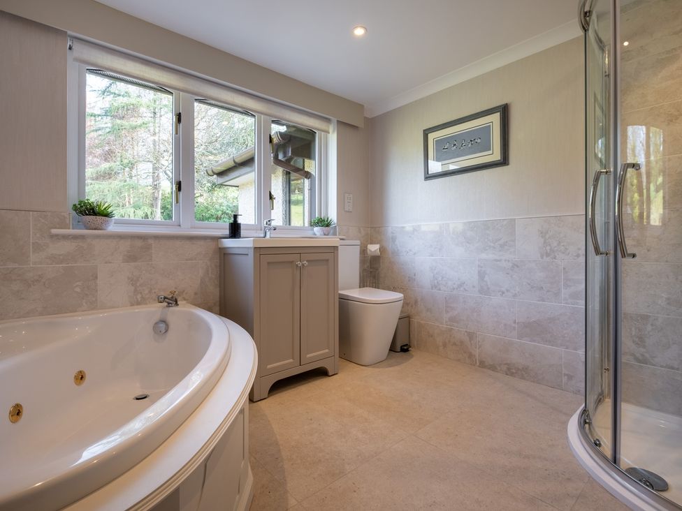 A bathroom with a bathtub, toilet, sink, and shower at Marina View in Bowness-On-Windermere