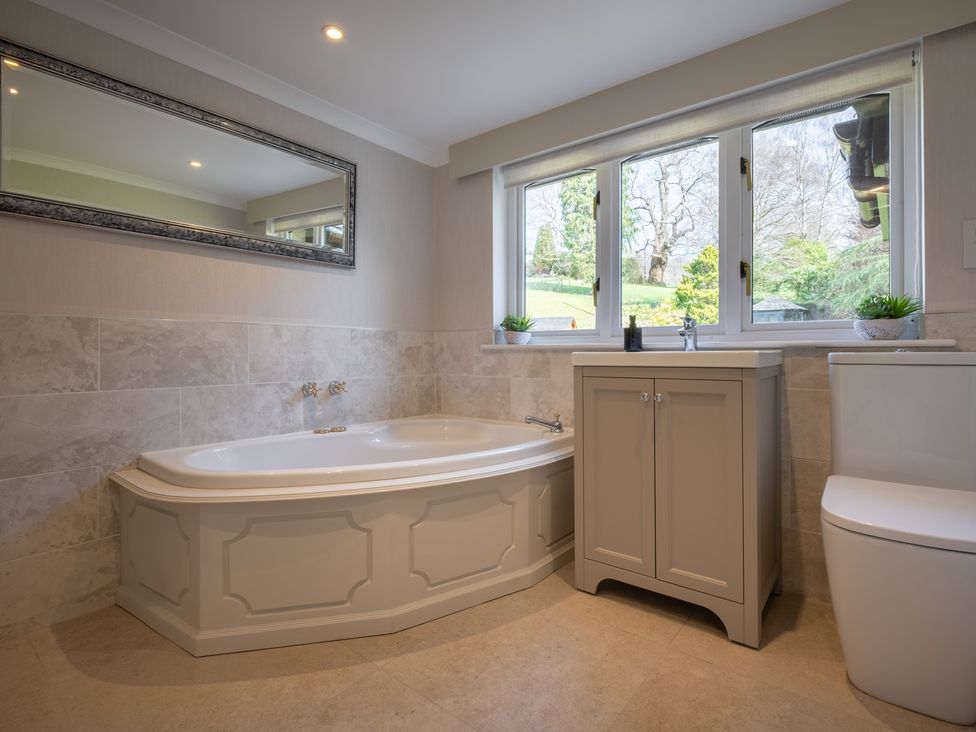A bathroom with a bathtub, sink, and toilet at Marina View in Bowness-On-Windermere