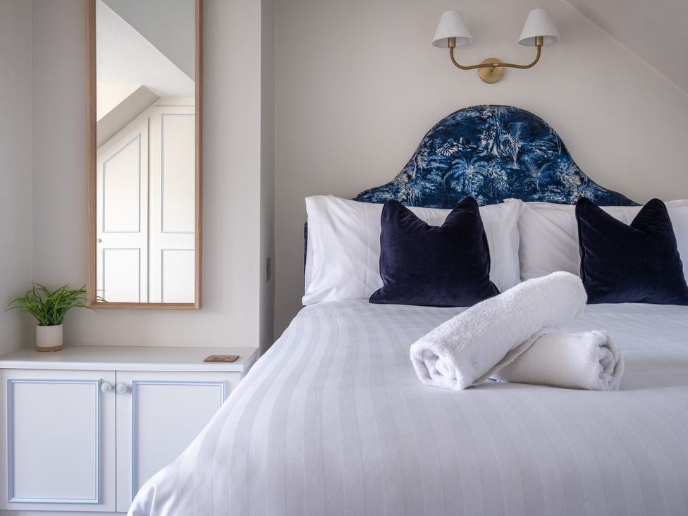 A bedroom with a bed and mirror at Marina View in Bowness-On-Windermere