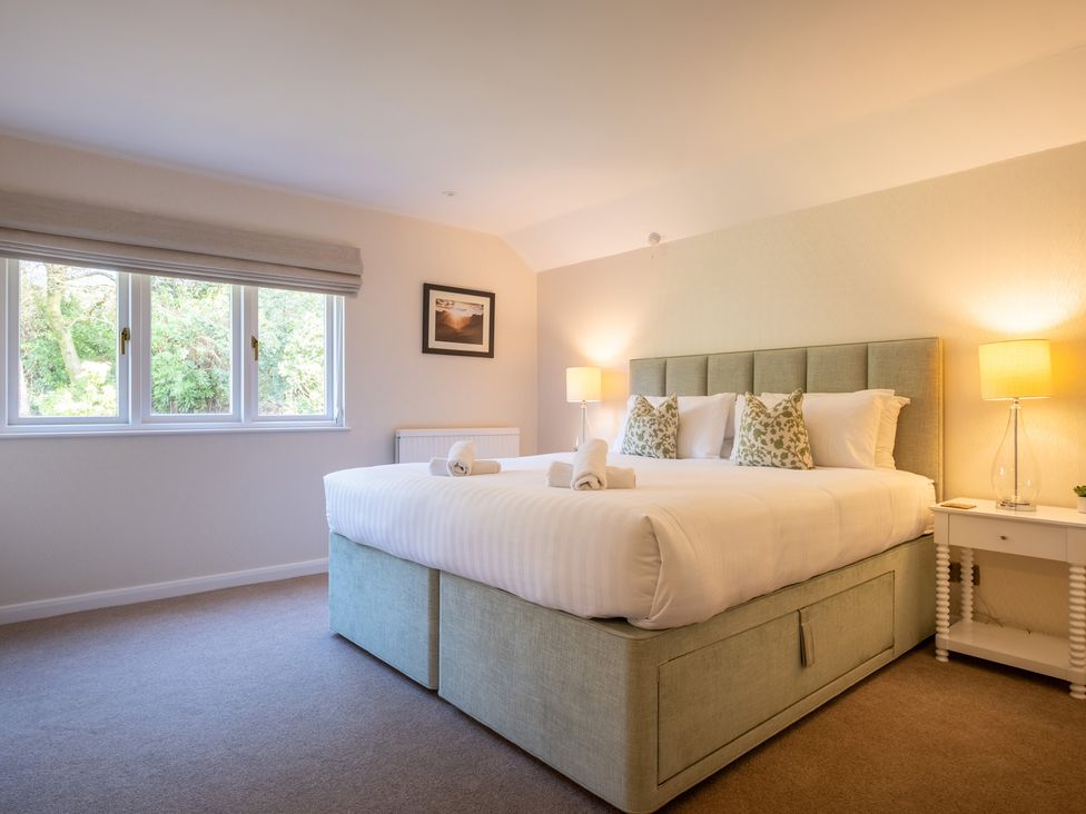 A bedroom with a large bed and window at Marina View in Bowness-On-Windermere