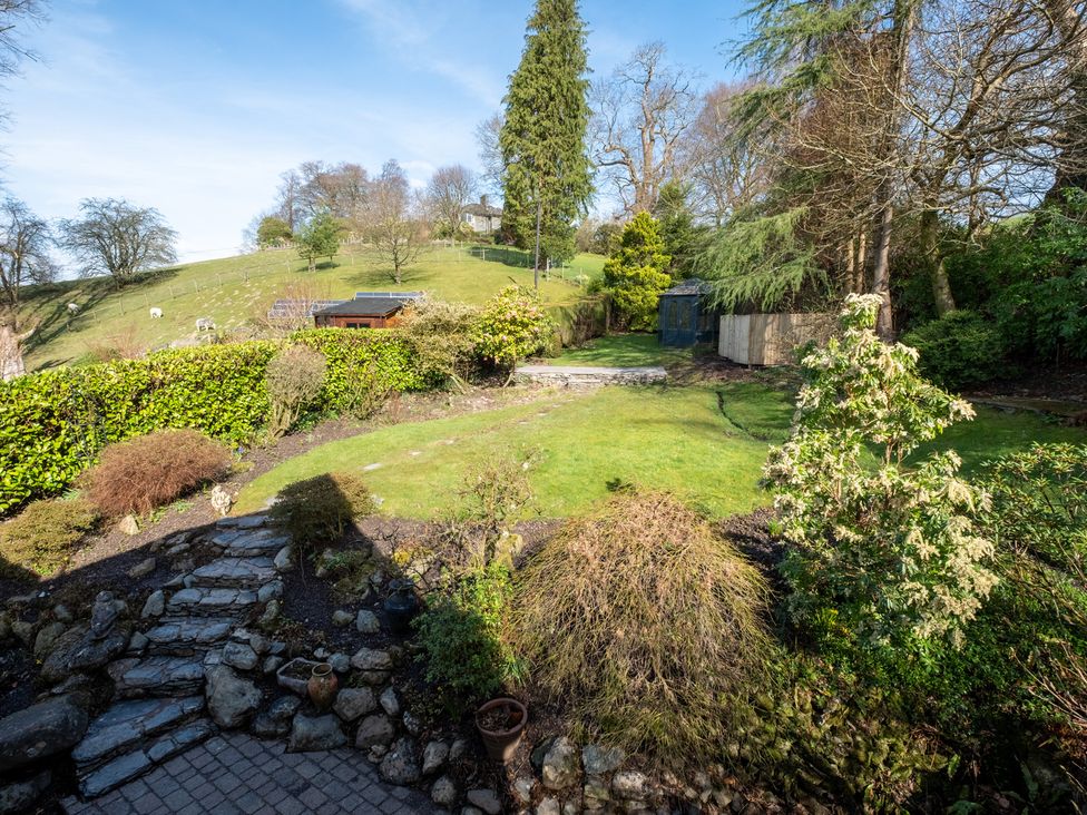 A garden with greenery and a shed at Marina View in Bowness-On-Windermere