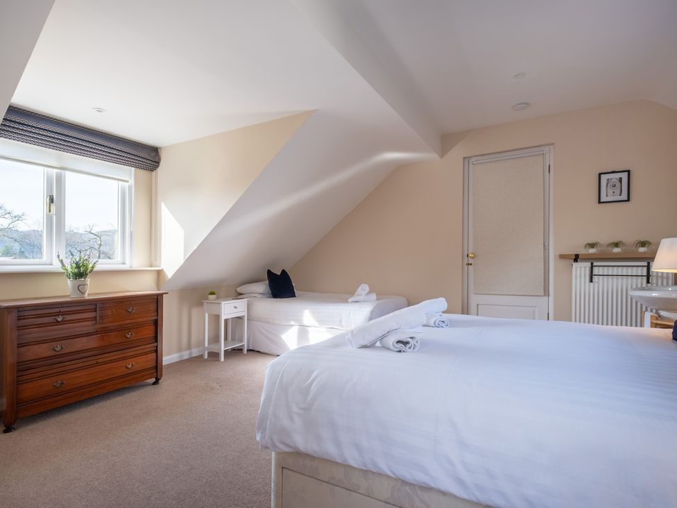 A bedroom with a window, dresser, and bed at Marina View in Bowness-On-Windermere