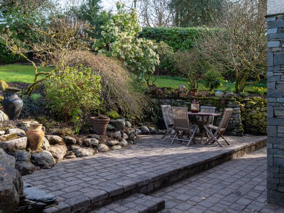 A garden with a table and chairs at Marina View in Bowness-On-Windermere