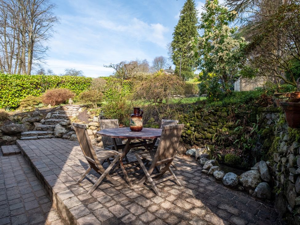 A garden with a table and chairs at Marina View in Bowness-On-Windermere