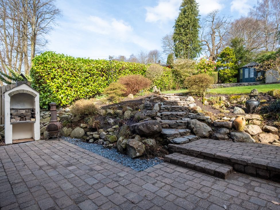 A garden with rock steps and an outdoor grill at Marina View in Bowness-On-Windermere