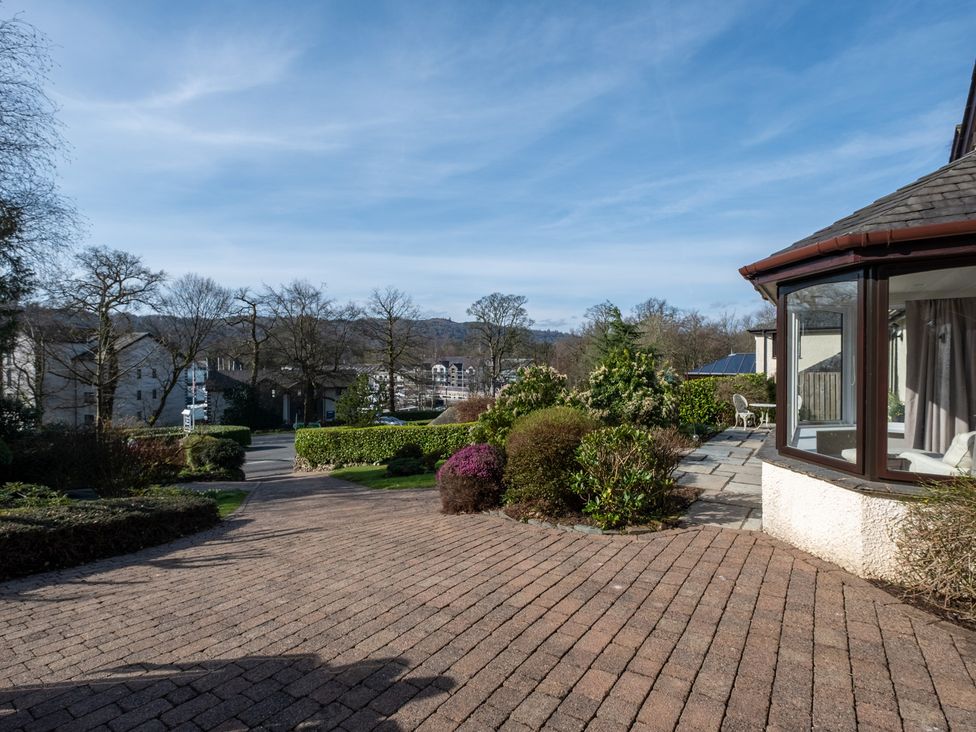 A garden with a pathway and flower beds at Marina View in Bowness-On-Windermere