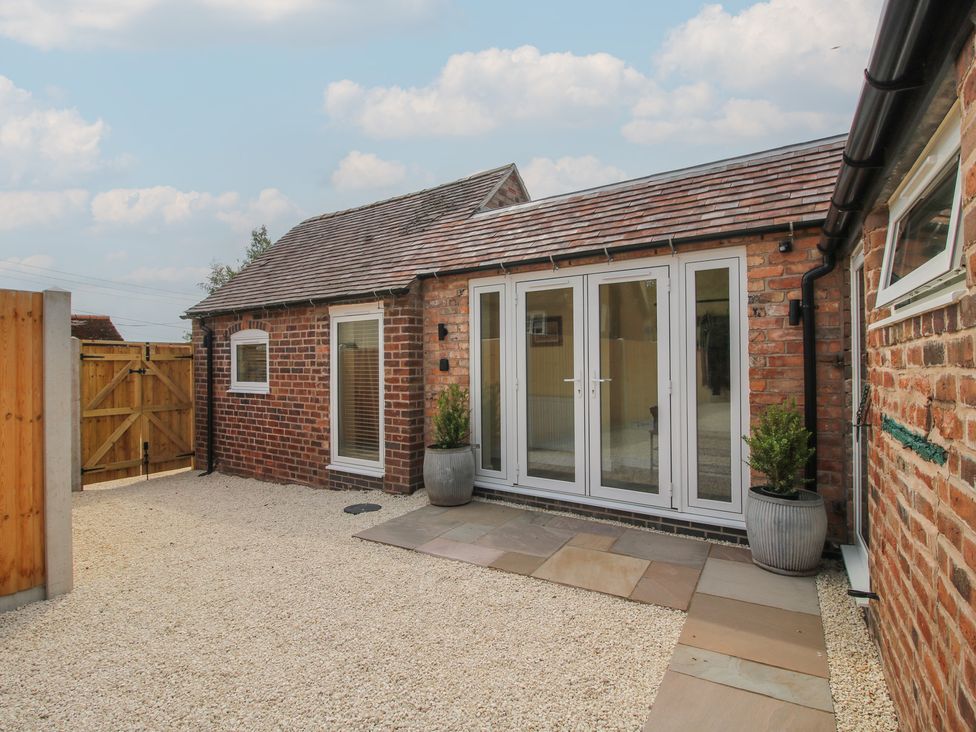 An outdoor area with brick walls and doors at The Old Piggery in Shifnal