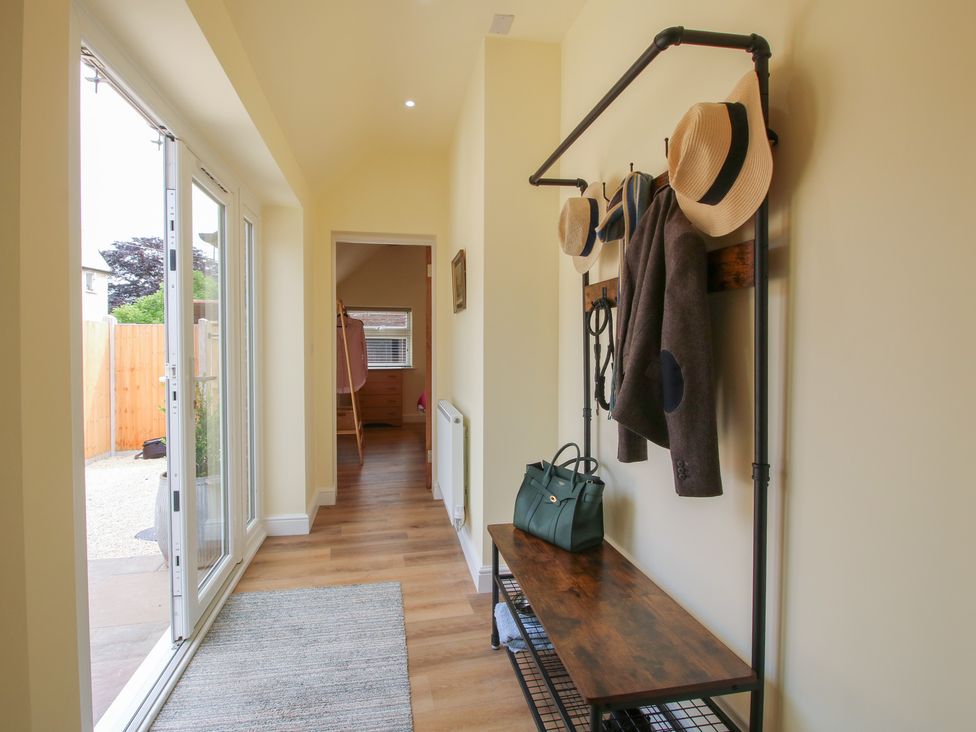 A hallway with a hat rack and bench at Old Piggery in Shifnal