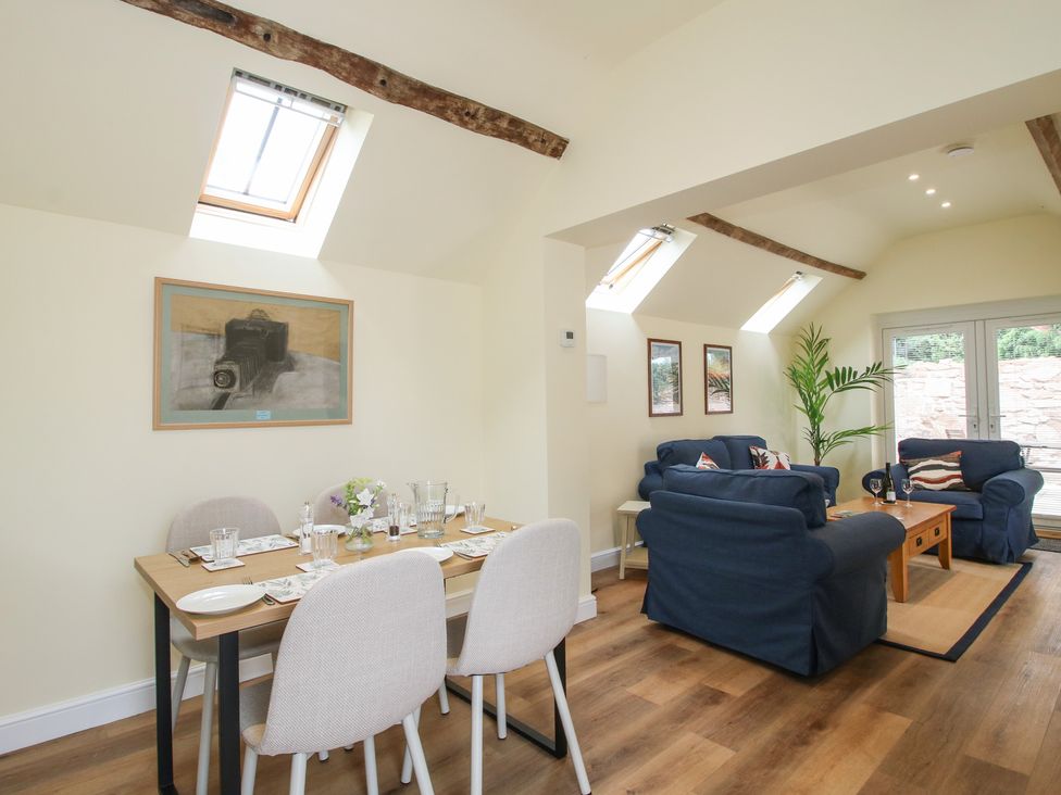 A living room with a sofa and dining area at The Old Piggery in Shifnal