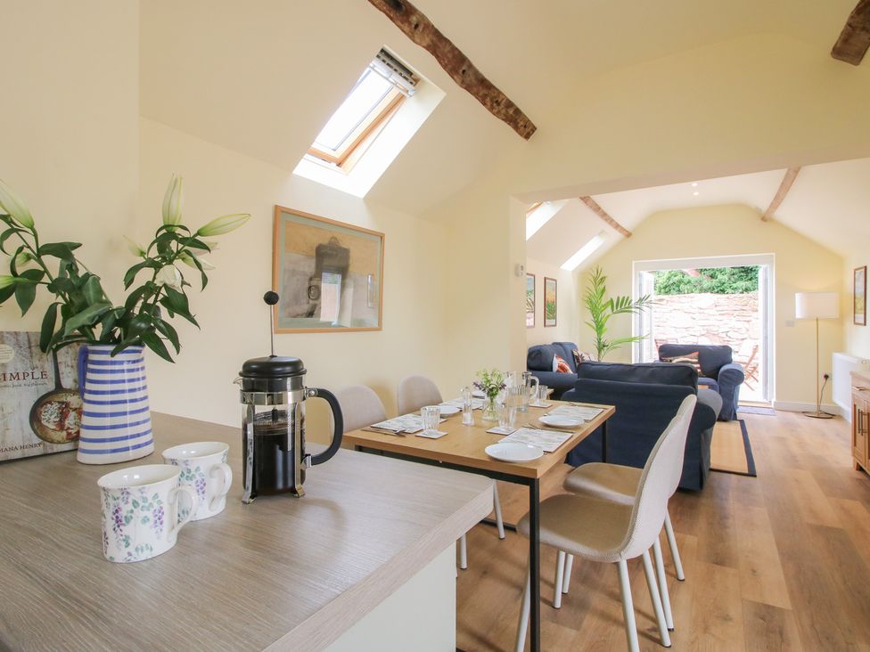 A dining room with a table set for meals at The Old Piggery in Shifnal