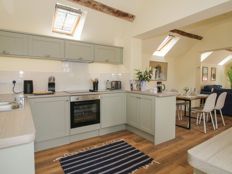 A kitchen with grey cabinets and appliances at The Old Piggery in Shifnal