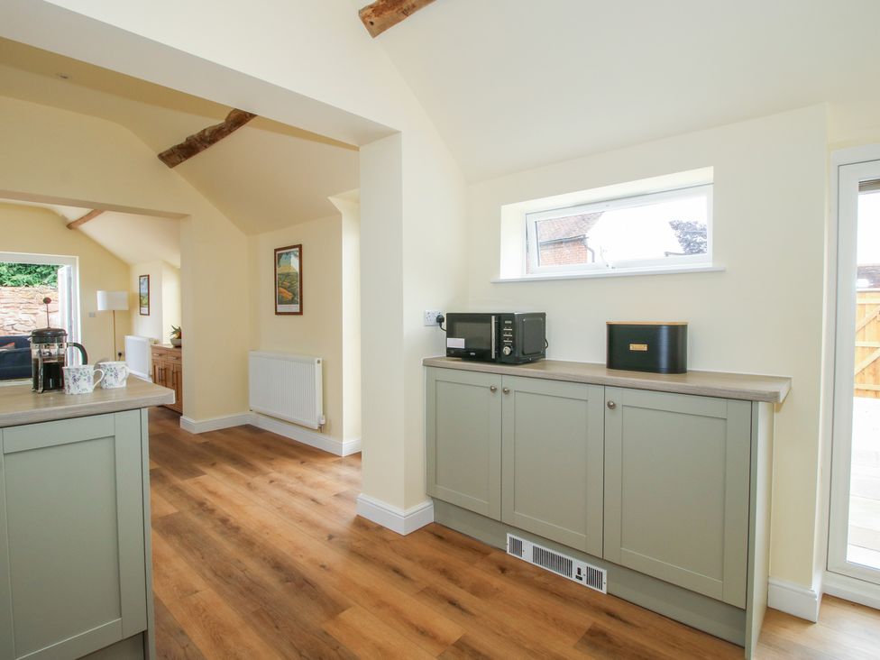 A kitchen with cabinets and a microwave at The Old Piggery in Shifnal