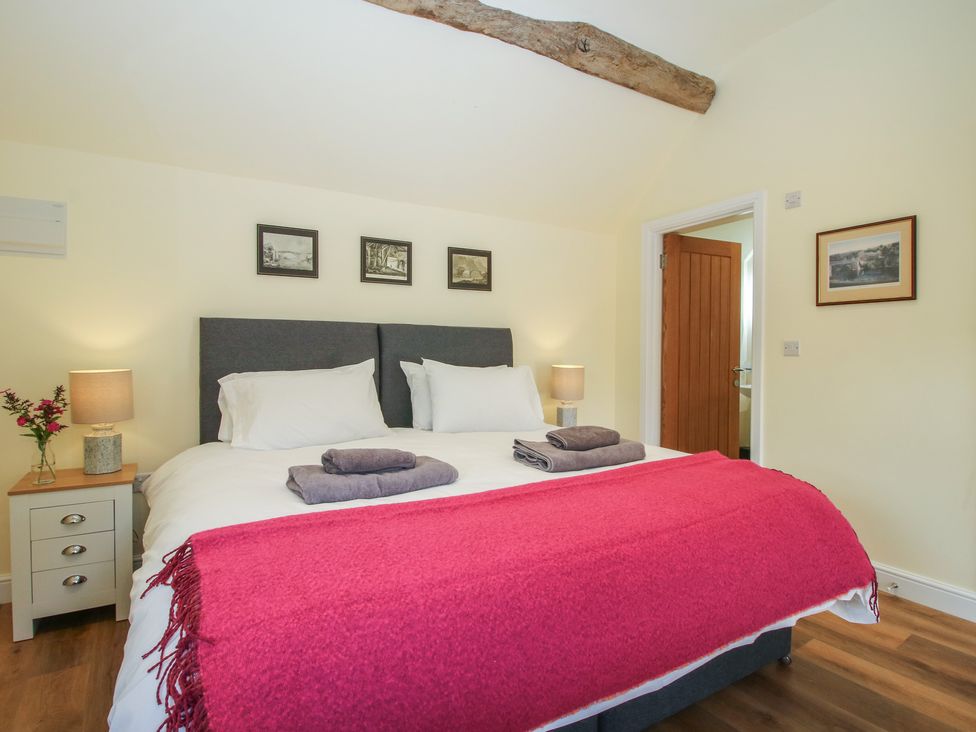A bedroom with a bed and side table at The Old Piggery in Shifnal