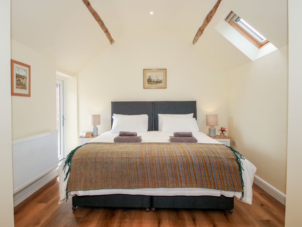 A bedroom with a double bed and two lamps at The Old Piggery in Shifnal