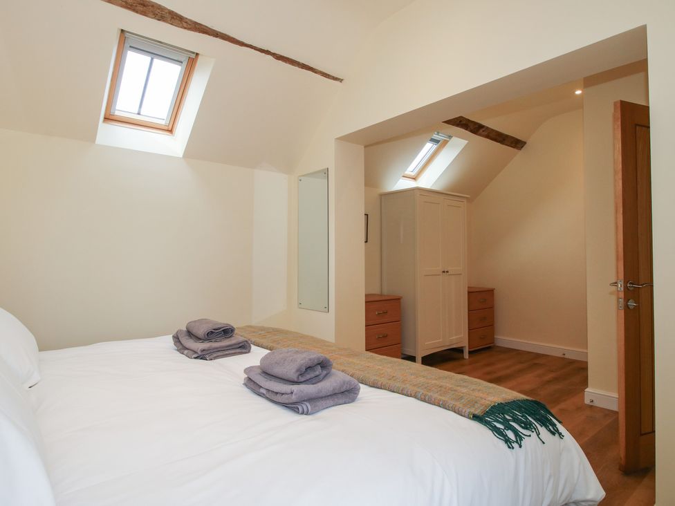 A bedroom with a bed and wardrobe at The Old Piggery in Shifnal