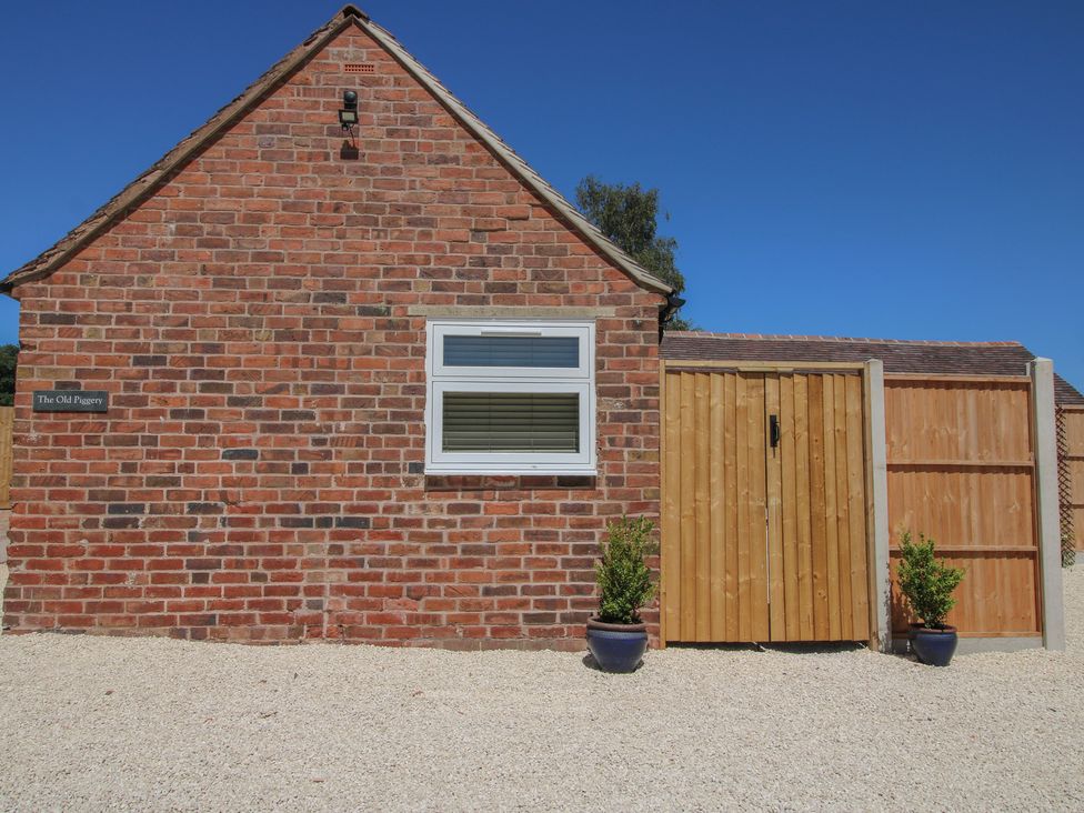 A brick building with a window and wooden door at The Old Piggery Ironbridge