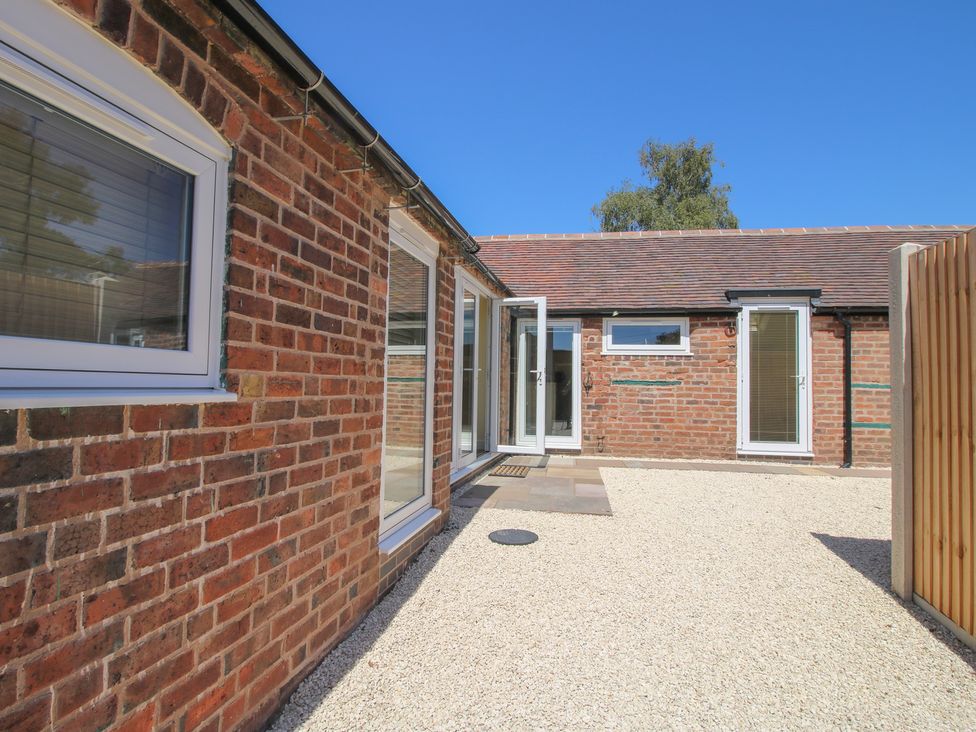 An outdoor area with brick walls and windows at The Old Piggery in Ironbridge