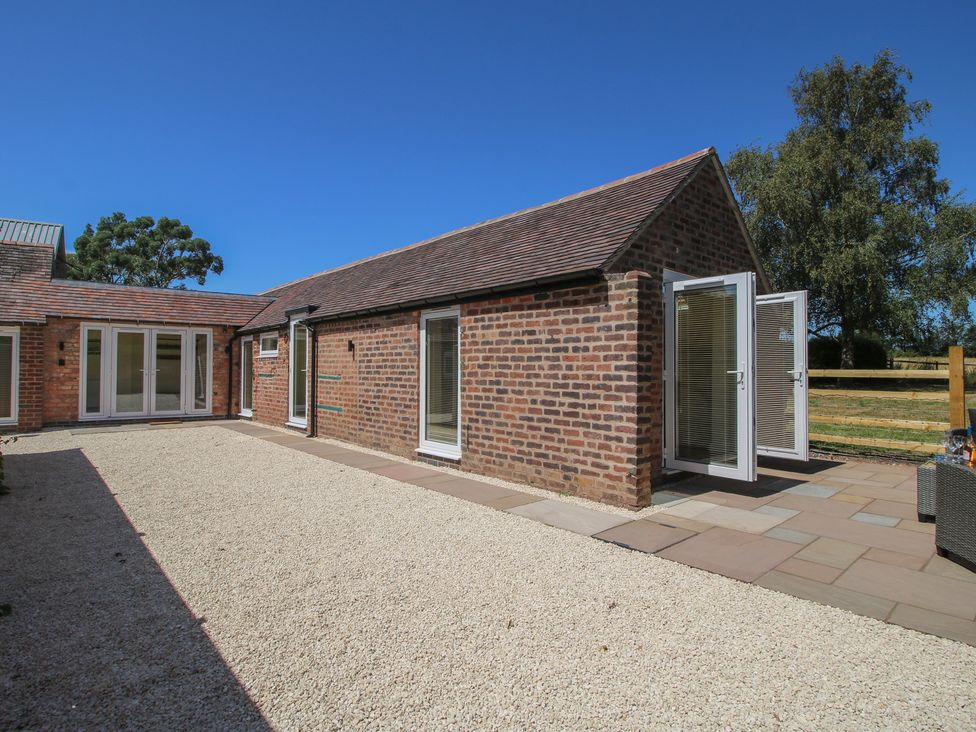 An outdoor area featuring a brick structure with doors and windows at The Old Piggery Ironbridge
