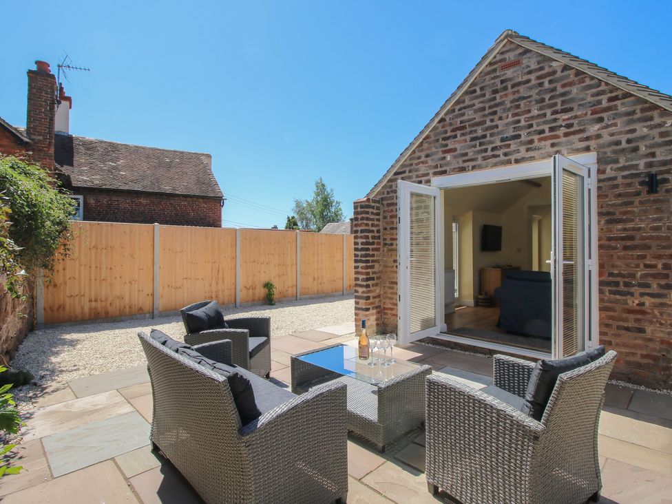 An outdoor seating area with a coffee table and fence at The Old Piggery in Ironbridge