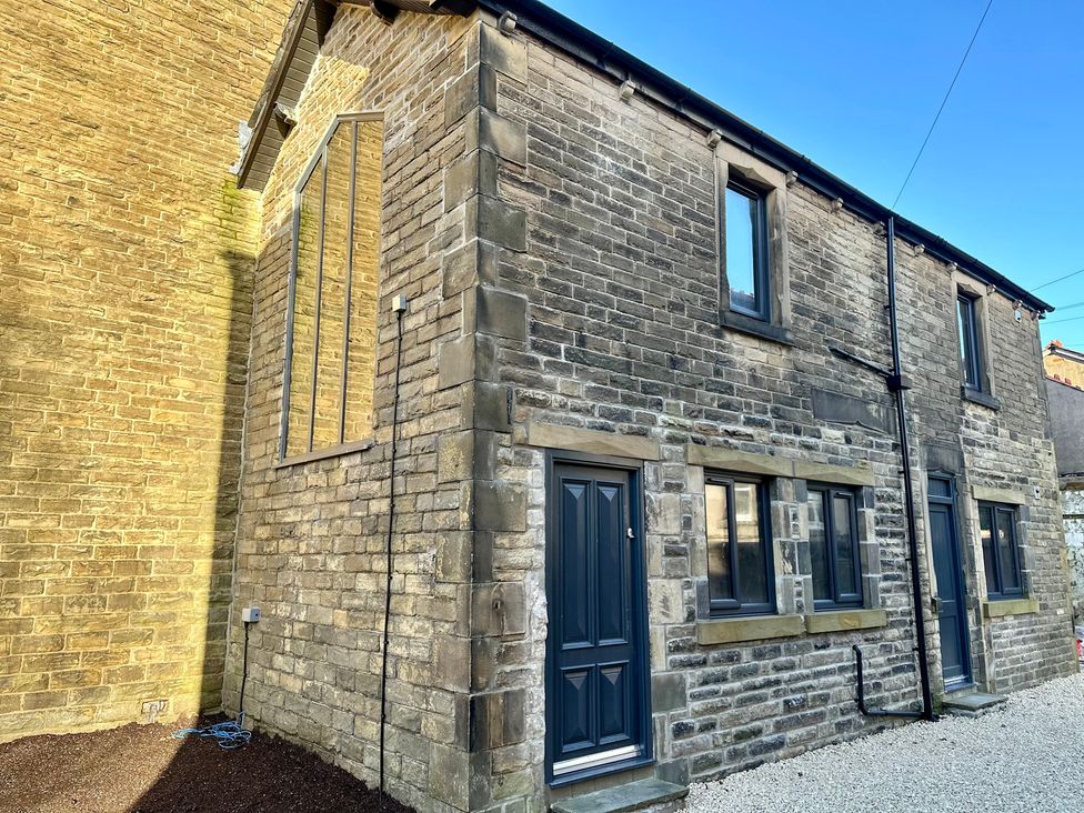 A stone building with windows and door at The Balmoral Coach House in Morecambe