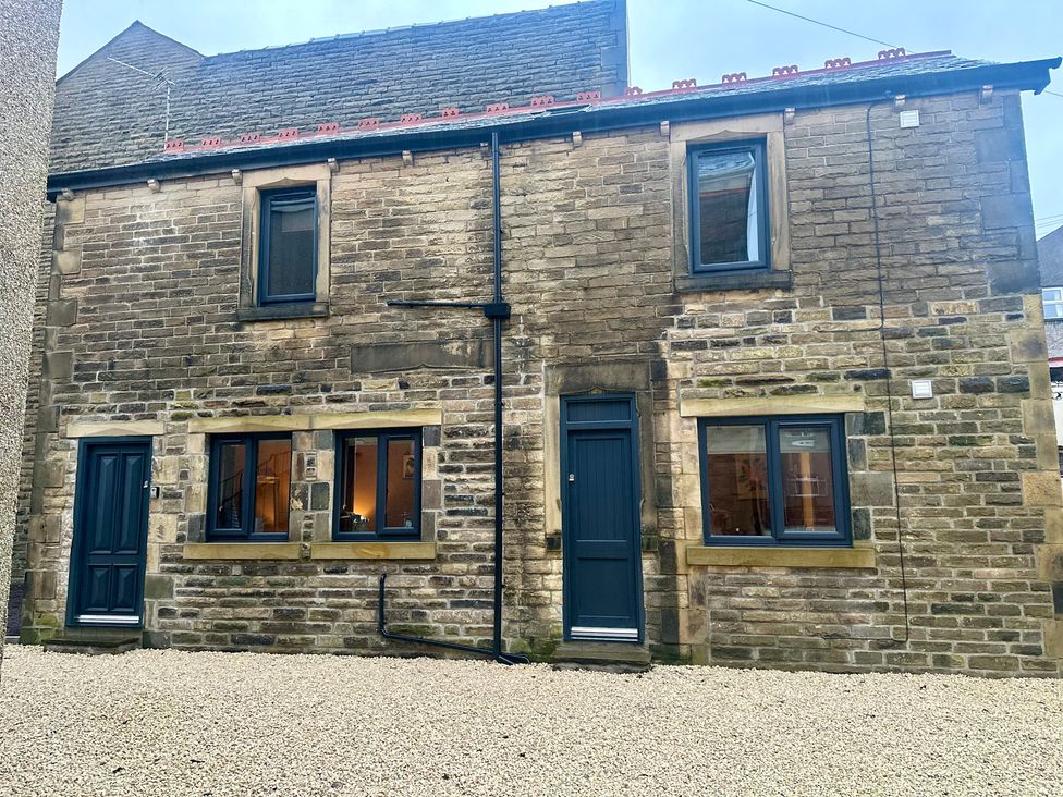 An outdoor view of a stone building with doors and windows at The Balmoral Coach House in Morecambe