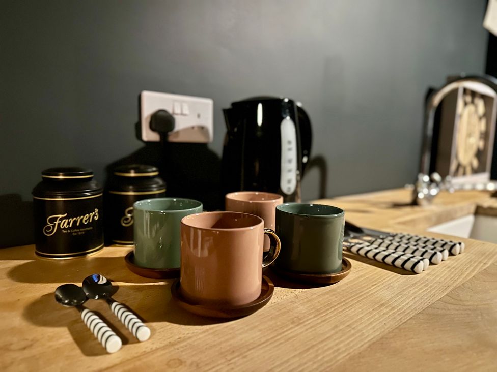 A kitchen counter with mugs and a kettle at The Balmoral Coach House in Morecambe