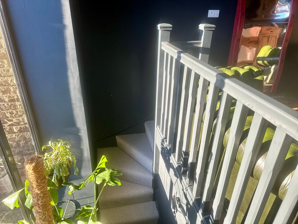 A staircase with a railing and plants at The Balmoral Coach House in Morecambe