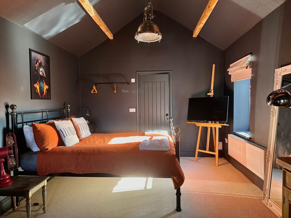 A bedroom with a bed and television at The Balmoral Coach House in Morecambe