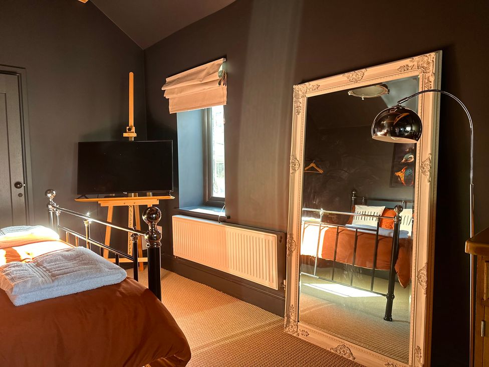 A bedroom with a bed and television at The Balmoral Coach House in Morecambe