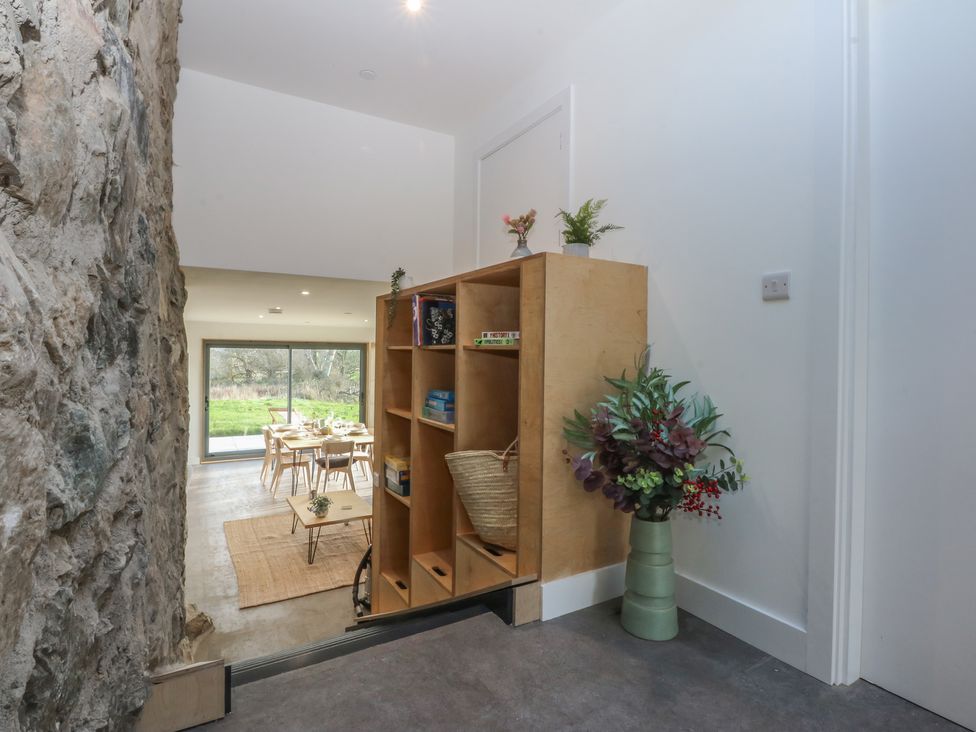 A dining room with a table and chairs at Tithe Barn Lodge Capel Mawr near Malltraeth