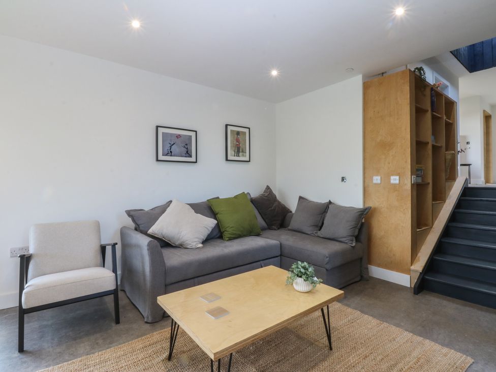 A living room with a sofa and armchair at Tithe Barn Lodge Capel Mawr near Malltraeth