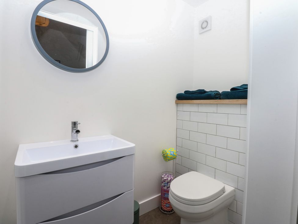 A bathroom with a sink and toilet at Tithe Barn Lodge in Capel Mawr near Malltraeth